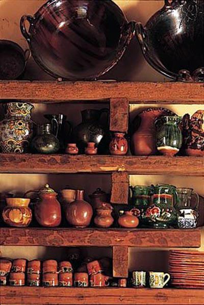 Открытые грубые полки из дерева на кухне в мексиканском стиле.