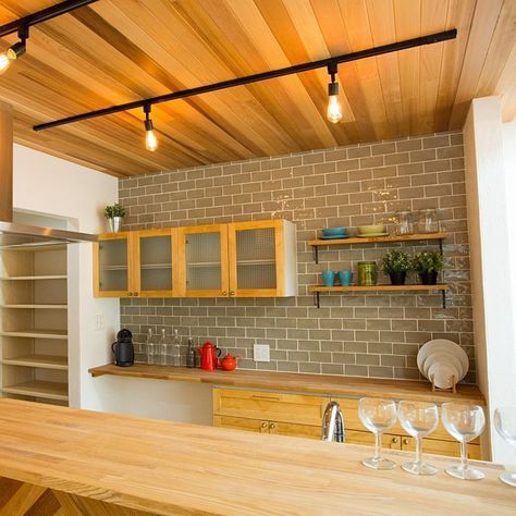 Стена японской кухни выложена серой плиткой до потолка