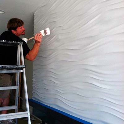 Покраска стены отделанной стеновыми панелями из гипса.