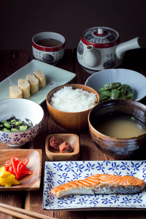 Традиционный японский завтрак, который включает рис, рыбу, мисо суп и овощное ассорти.