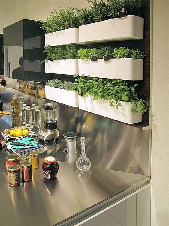 Пластиковые ящики для растений установлены над фартуком кухни 